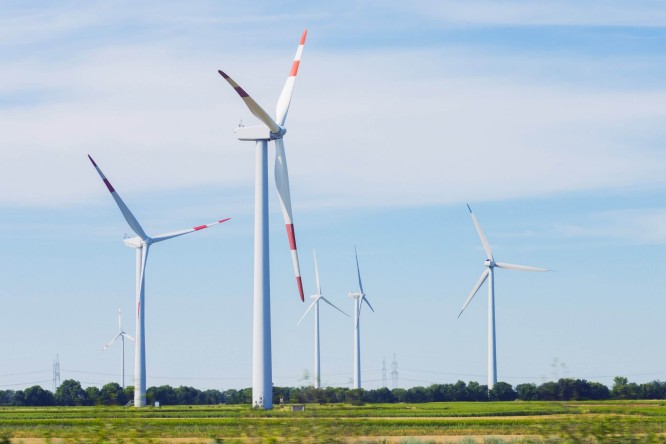 Windkraftanlagen auf einem Feld bei blauem Himmel - Regionalität, Nachhaltigkeit und Unabhängigkeit